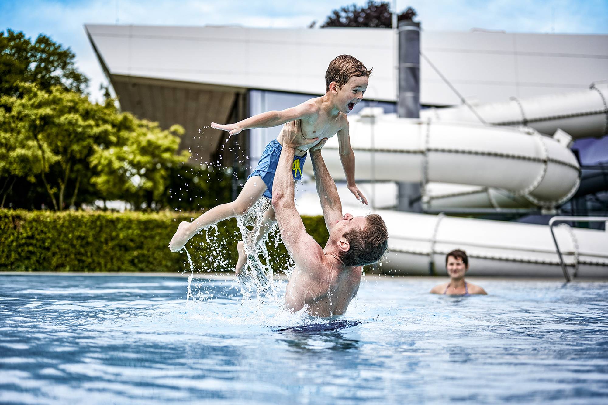 Freizeitbad Außenbecken, Vater und Sohn spielen im Wasser