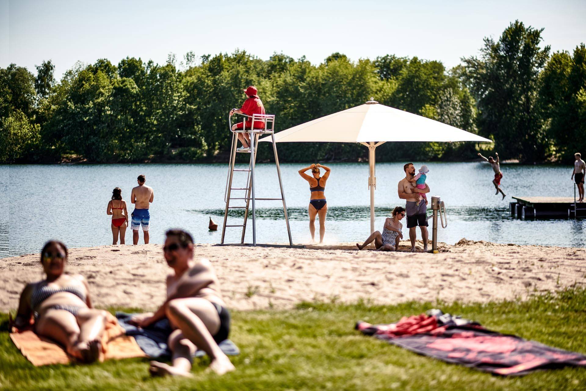 Strandbad, Menschen im Sand und auf der Wiese